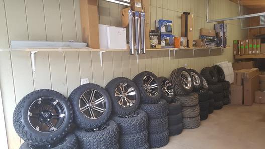 A wall of tires and rims in a garage.