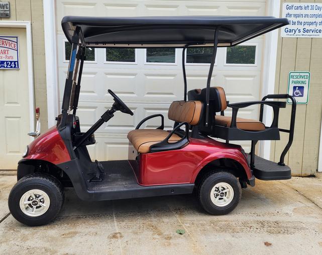 A red golf cart parked in front of a garage door.