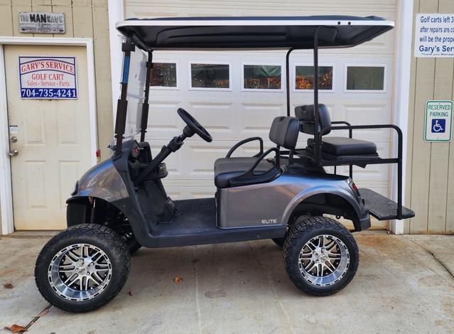 A golf cart with two seats and a large tire.