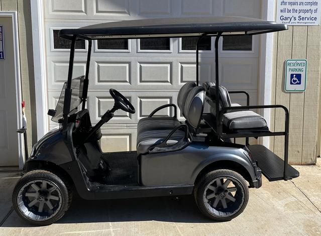 A golf cart parked in front of a garage door.