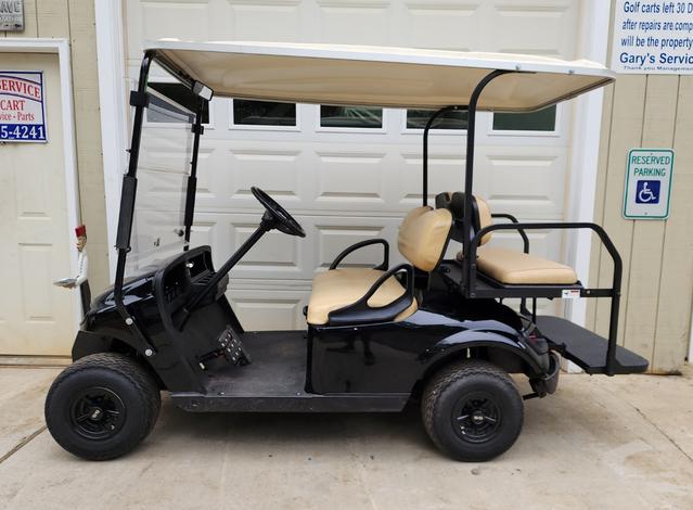 A golf cart is parked in front of the garage.