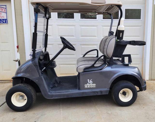 A golf cart parked in front of a garage door.
