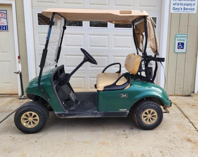A green golf cart parked in front of a garage door.
