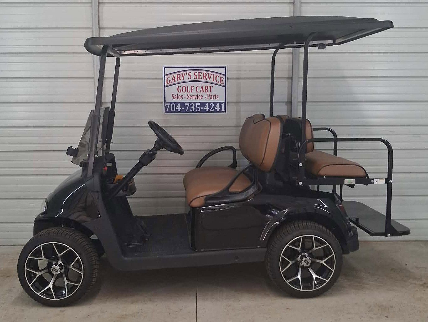Black four seat golf cart with tan seats