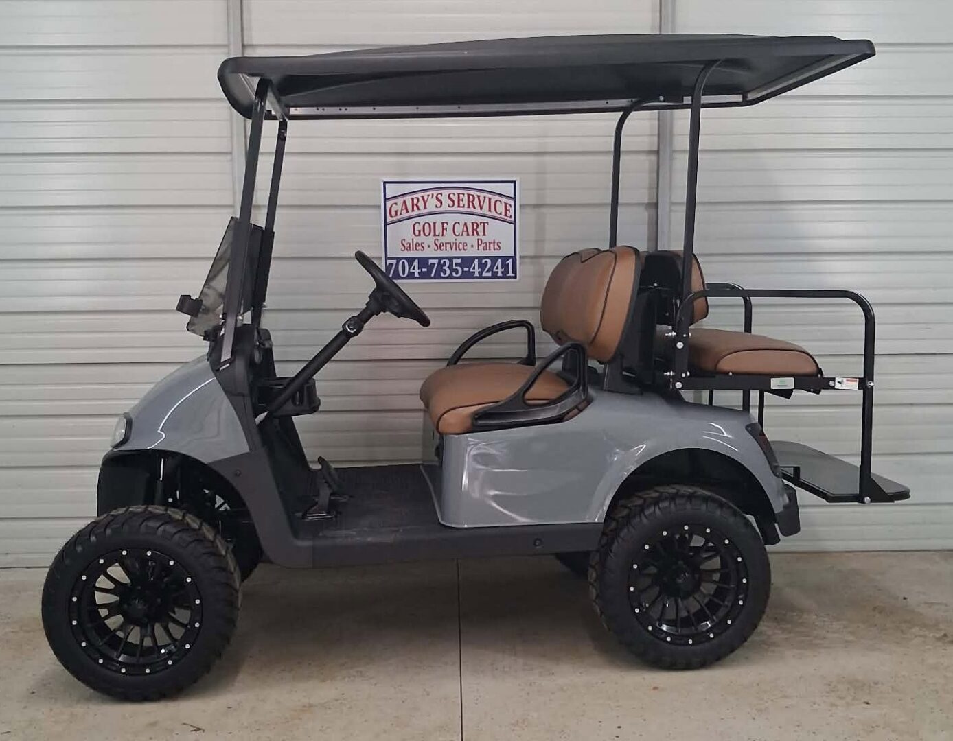 Gray lifted golf cart with brown seats