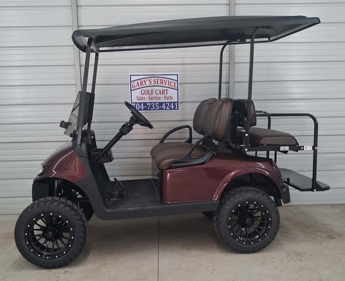 Maroon lifted golf cart with rear seat